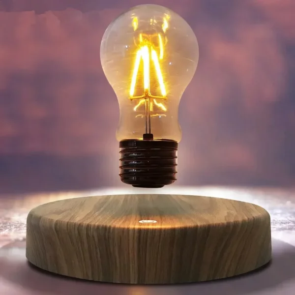 Magnetic-Levitation-Lamp-Creativity-Floating-Glass-LED-Bulb-Home- The Floating Light Bulb by Simon Morris showcases a levitating bulb with a wooden base, illuminating gracefully against a softly focused backdrop.