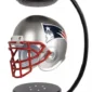 A silver football helmet with a red faceguard is levitating inside a black display stand.
