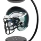 Levitating miniature football helmet with an eagle logo, suspended between two black magnetic bases.