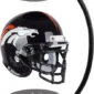 A black football helmet with a horse logo is suspended between two magnetic bases, supported by a curved rod.
