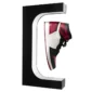 A black, white, and red high-top sneaker displayed hovering in a C-shaped stand.
