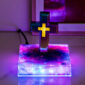 The Floating Cross Nightlight features an illuminated Greek cross standing on a vibrant, galaxy-themed base, casting ambient lighting across its surface.
