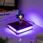 A Floating Cross Nightlight on a desk emits purple light, illuminating a nearby Holy Bible, a Harry Potter book, and a cup.