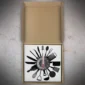 An open cardboard box reveals a wall clock with a culinary theme, featuring kitchen utensil shapes as hour markers.