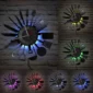 Wall clock with kitchen utensil design and glowing colored backlights.