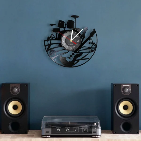 Guitar and Drum Kits Wall Clock Guitar Player Music Vinyl Record Clock Rock Music Instrument Guitar Wall Art Rock n Rock Gift 4 Wall clock with musical instrument designs, above a record player and two speakers, set against a blue wall.