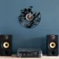 Wall clock with musical instrument designs, above a record player and two speakers, set against a blue wall.