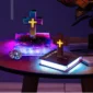 Colorful illuminated crosses on books with glowing bases are displayed on a wooden table alongside a decorative object.