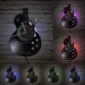 A guitar-shaped wall clock with vinyl record design and multiple LED backlight colors mounted on a brick wall.