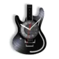 Wall clock designed in the shape of a black electric guitar, featuring a round clock face in the center with white hour and minute hands and a red second hand.
