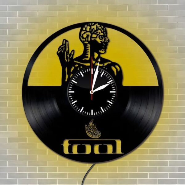 Skeletal Brain Wall Clock 1 Skeletal Brain Wall Clock crafted from a vinyl record features an artistic design of a human figure and the word "tool" on a brick wall.