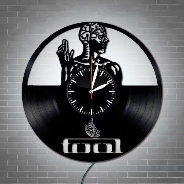 The Skeletal Brain Wall Clock is crafted from a vinyl record and showcases a design featuring a human figure with a brain, spine, and flame symbol, along with the word "Tool" at the bottom.