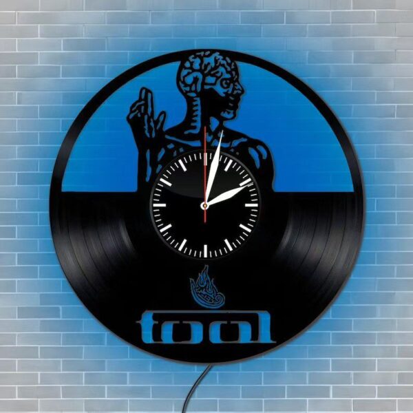 Skeletal Brain Wall Clock 3 The Skeletal Brain Wall Clock is crafted from a vinyl record, showcasing an artistic design of a human figure with the word "fool" at the bottom, set against a blue brick wall background.
