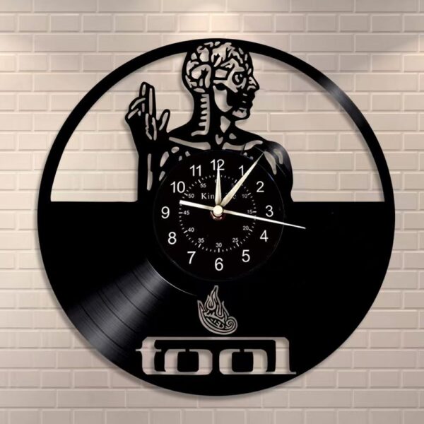 Skeletal Brain Wall Clock 7 The Skeletal Brain Wall Clock features a vinyl record design with a stylized human figure and the word "tool" at the bottom, all set against a brick background.