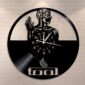 The Skeletal Brain Wall Clock features a vinyl record design with a stylized human figure and the word "tool" at the bottom, all set against a brick background.