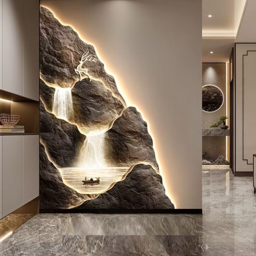 The Mountain Wall Light creates a stunning illuminated mural of a waterfall and a small boat on a river, perfect for any elegantly designed interior space.