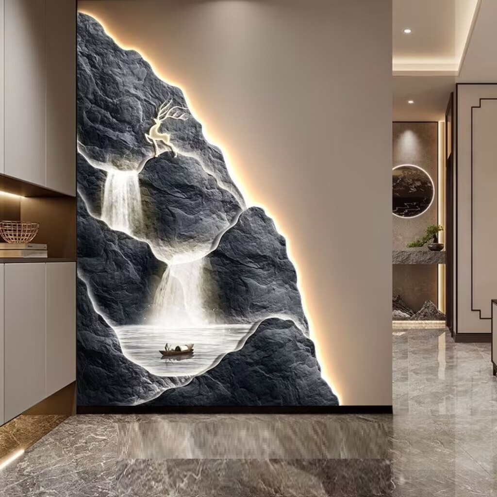 The Mountain Wall Light displays a backlit mountain scene with a waterfall, deer, and boat. It's set in a room with glossy marble flooring and modern decor.