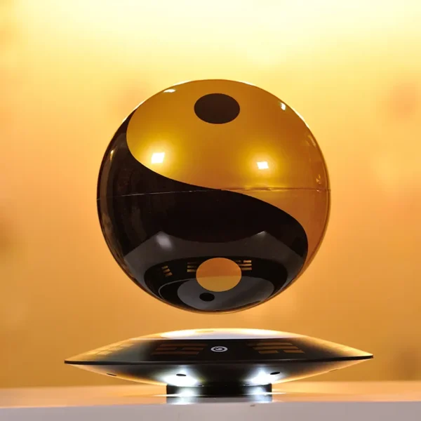 A black and gold yin-yang sphere levitates above a circular base on a warm yellow background.