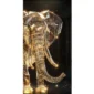 A sparkling, faceted crystal sculpture of an elephant, gleaming with golden light against a dark background.
