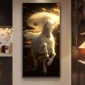 Painting of a majestic white horse with flowing mane, surrounded by golden light and particles, hanging on a wall.