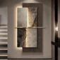 Abstract wall art with a textured, layered design and soft lighting. The piece features a vertical division with subtle earth tones, mounted on a stairwell wall.