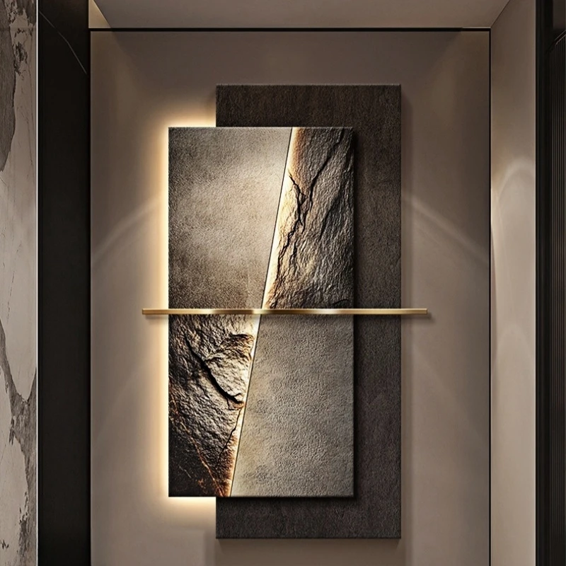 A modern wall art installation featuring two rectangular panels with textured, stone-like surfaces and a horizontal metallic bar across the center. The backlighting highlights the textures.